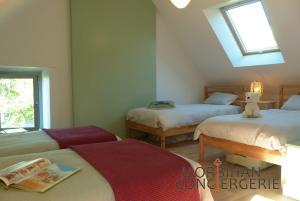 a bedroom with two beds and a teddy bear on the bed at Belle longère en campagne à Larmor Baden in Larmor-Baden