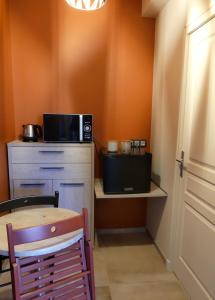 a small kitchen with a table and a microwave at Chambres D'hôtes Les Ambaciales in Amboise