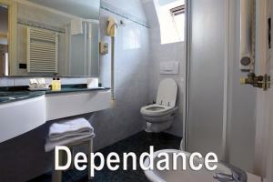 a bathroom with a toilet and a sign that reads dependency at Hotel Aurora in Rimini