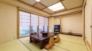 高知市にある高知パシフィックホテルのテーブルと椅子、テレビが備わる客室です。