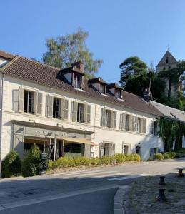 a large white building on the side of a street at Auberge du Chasseur in Grosrouvre