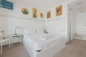 ein weißes Schlafzimmer mit einem weißen Bett und einem Schreibtisch in der Unterkunft HostMe flat Metro Spagna in Rom