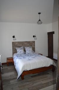 una camera con un grande letto con testiera in legno di Les mansardes Le gîte a Sarlat-la-Canéda