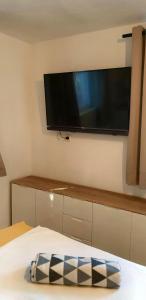 einen Flachbild-TV an einer Wand über einem Bett in der Unterkunft Island Stone House in Ždrelac