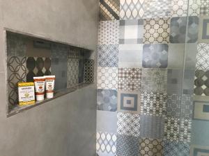 a bathroom with a tiled wall with different colored tiles at Pousada Yemanjá Toré in Barra de Camaratuba