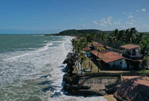 an aerial view of a house on a cliff next to the ocean at Pousada Yemanjá Toré in Barra de Camaratuba