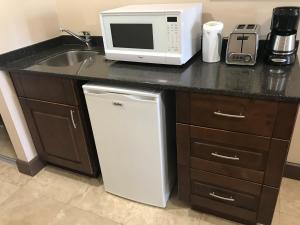 a kitchen with a sink and a microwave and a refrigerator at Coconut Court Beach Hotel in Bridgetown