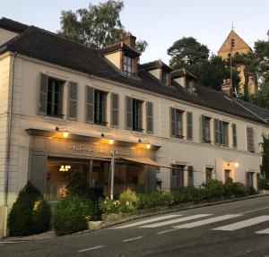 a white building on the side of a street at Auberge du Chasseur in Grosrouvre