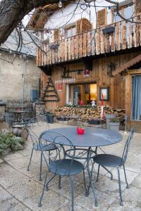 une table et des chaises devant un bâtiment dans l'établissement Auberge De La Foret, à Auris