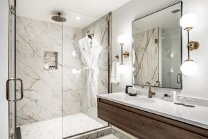 La salle de bains est pourvue d'un lavabo et d'une douche. dans l'établissement Bottleworks Hotel, à Indianapolis