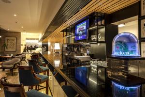 a bar in a restaurant with chairs and televisions at Pullman Vina del Mar San Martin in Viña del Mar