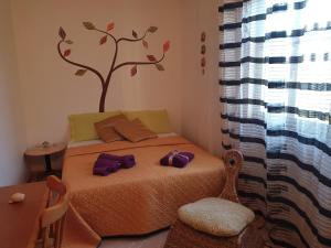 1 dormitorio con 1 cama con un árbol en la pared en Casa Vacanze Lorenzo marzamemi, en Marzamemi