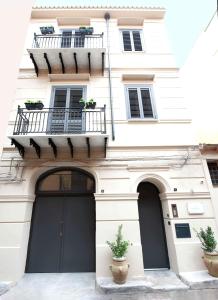 a white building with two doors and a balcony at Palazzo al Carmine in Monreale