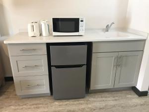 a kitchen counter with a microwave and a sink at Coconut Court Beach Hotel in Bridgetown