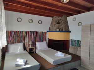 1 dormitorio con 2 camas y chimenea en Ioli's Apartments, en Archangelos