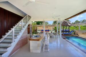 een poolhouse met een bar en een zwembad bij Villa Bukit Nusa Lembongan in Nusa Lembongan