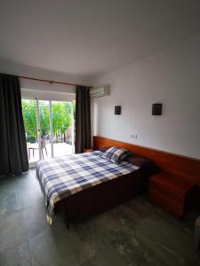 a bedroom with a bed and a large window at Hostal Villa Catí in Paguera