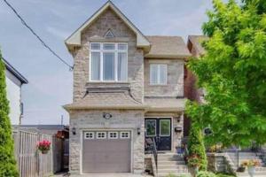 a brick house with a garage in front of it at Spacious 2 Bedroom guest suite in Toronto