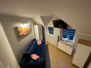 a living room with a blue couch and two windows at Pod Żaglami in Dąbki