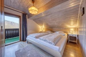 a bedroom with a bed and a large window at Goldbichlhof in Lana