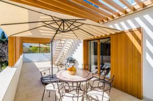 a patio with a table and chairs under an umbrella at Apartment Lula in Orasac