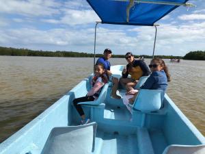 un grupo de personas sentadas en un barco azul en el agua en Hotel Posada Mercy, en Río Lagartos