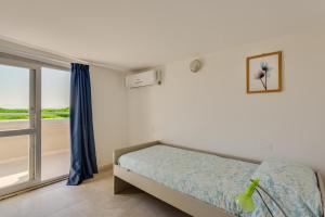 a bedroom with a bed and a large window at Oltremare Appartamenti in Principina a Mare