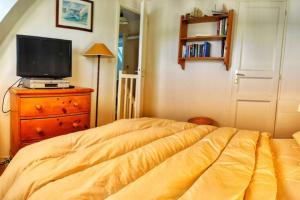 een slaapkamer met een bed en een televisie op een dressoir bij Les Balcons de La Trinité - Vue sur mer et le port in La Trinité-sur-Mer