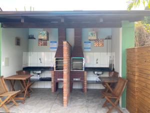 un restaurante con mesas y sillas de madera y una cocina en Residencial Caminho das Ondas, en Bombinhas