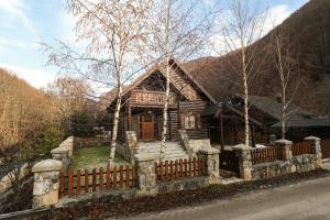 a wooden house with a fence in front of it at Holiday Home Bianca in Kolašin