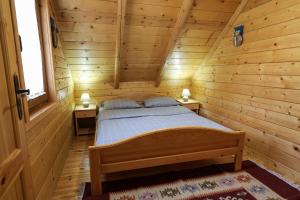 a bedroom with a bed in a wooden cabin at Holiday Home Bianca in Kolašin