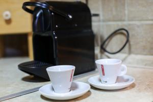dwie filiżanki kawy siedzące na ladzie obok tostera w obiekcie Holiday Home Bianca w mieście Kolašin