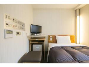 横浜市にあるR&B Hotel Shin Yokohama Ekimae - Vacation STAY 14693vのベッド2台とテレビが備わるホテルルームです。