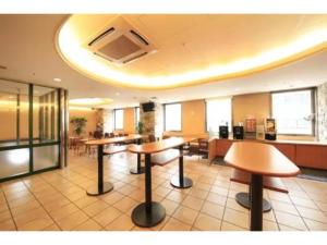um átrio com mesas e cadeiras num edifício em R&B Hotel Shin Yokohama Ekimae - Vacation STAY 14694v em Yokohama