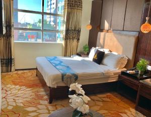 a hotel room with a large bed and a large window at Hotel Noorjahan Grand in Sylhet