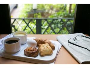 einen Teller Gebäck und zwei Tassen Kaffee auf dem Tisch in der Unterkunft R&B Hotel Kumagaya Ekimae - Vacation STAY 14848v in Kumagaya