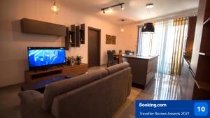 a living room with a couch and a flat screen tv at Msiebah Court San Gwann Modern Apt near Sliema and St Julians in San Ġwann