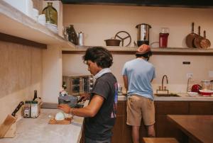 deux hommes debout dans une cuisine préparant la nourriture dans l'établissement Hostal Barrio Vivo, à Mérida