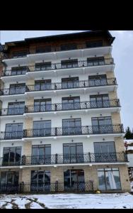 un alto edificio bianco con balconi di President Kop S9, S3 & A102 a Kopaonik
