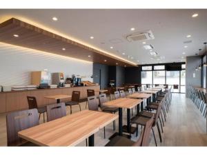 a dining room with wooden tables and chairs at R&B Hotel Nagoya Shinkansenguchi - Vacation STAY 15002v in Nagoya