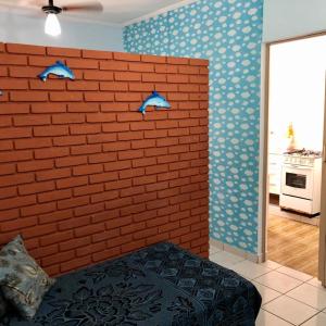 a bedroom with two blue birds on a brick wall at Aparkit Vila Caiçara in Solemar