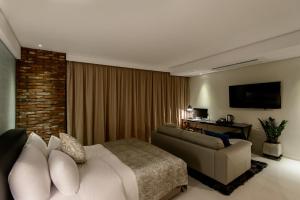 ein Hotelzimmer mit einem Bett und einem Sofa in der Unterkunft JB Design Hotel in Busan