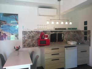 a kitchen with a table and a red microwave at Szélrózsa apartmanház in Velence