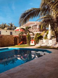 un complejo con piscina y casa en Posada Las Palmas, en Coyuca