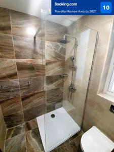 La salle de bains est pourvue d'une douche avec une porte en verre. dans l'établissement Msiebah Court San Gwann Modern Apt near Sliema and St Julians, à San Ġwann