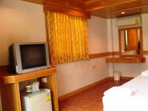 Habitación con TV pequeña y nevera pequeña. en Koh Chang Thai Garden Hill Resort, en Ko Chang