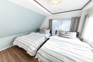 two beds sitting next to each other in a bedroom at CASA SHINAGAWA UNO - Vacation STAY 18212v in Tokyo