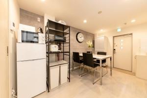 eine Küche und ein Esszimmer mit einem Kühlschrank und einem Tisch in der Unterkunft CASA SHINAGAWA UNO - Vacation STAY 18221v in Tokio