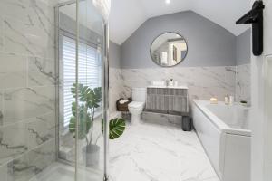 a bathroom with a shower and a toilet and a sink at South View - 3 bed modern Chester house - Close to city centre in Chester +25 photos