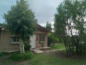 una pequeña casa con un árbol delante en Cabañas Aike en San Rafael